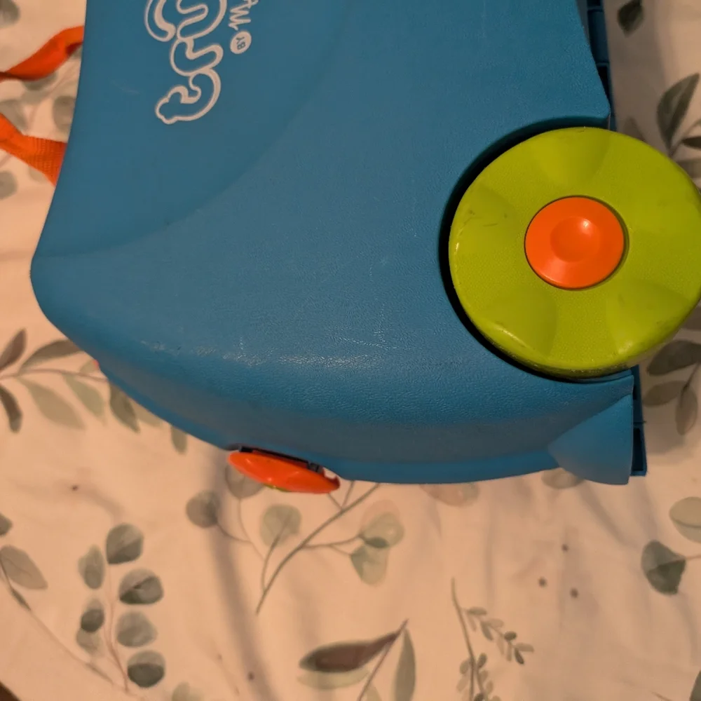 Melissa & Doug blue ride-on Trunki with green wheels and orange handle